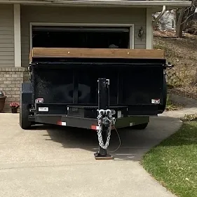 8 yard dumpster trailer in front of garage